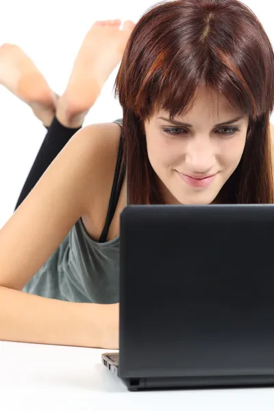 Belle femme couchée et regardant un ordinateur netbook — Photo