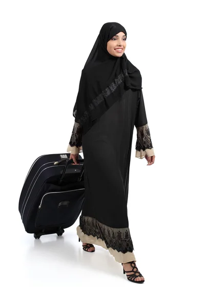 Mujer árabe caminando llevando una maleta — Foto de Stock