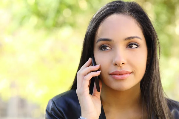 Ritratto di una bella donna sul cellulare in un parco — Foto Stock