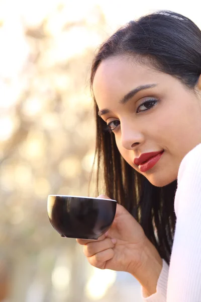 Mulher bonita segurando uma xícara de café ao ar livre — Fotografia de Stock