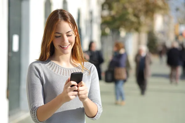 Kvinnan på gatan surfar en smart telefon — Stockfoto