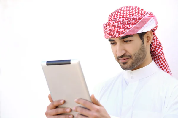 Uomo arabo che legge un tablet all'aperto su bianco — Foto Stock