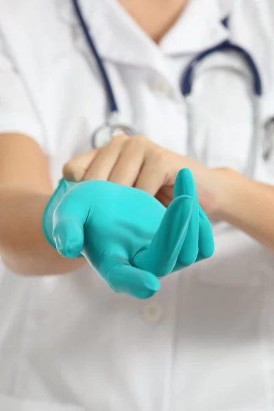 Primer plano de una doctora poniendo guantes de látex verde —  Fotos de Stock