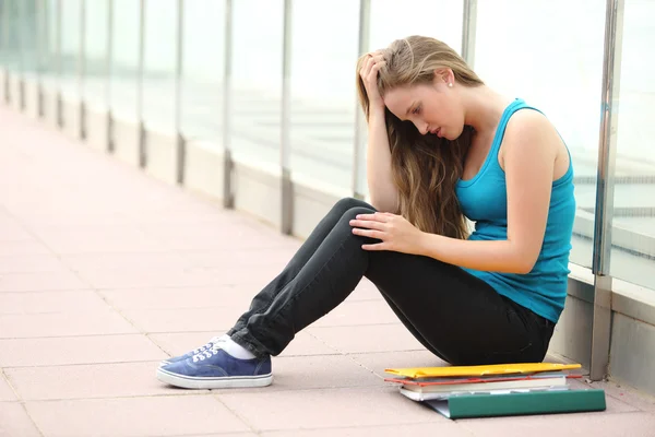 Beautiful teenager girl depressed sitting on the floor outdoor — Stock Photo, Image