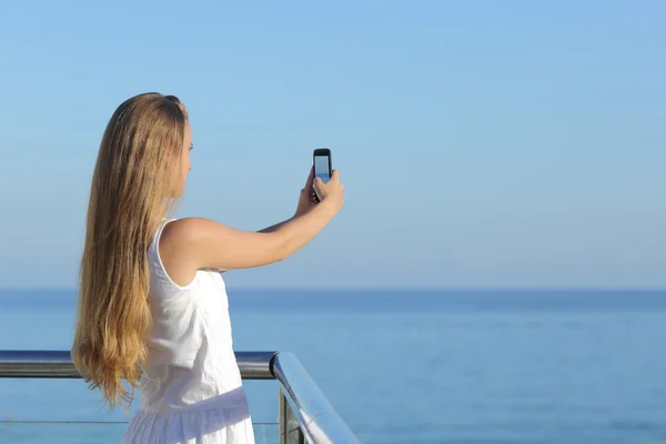 制作一张照片的大海与智能手机的女人 — 图库照片