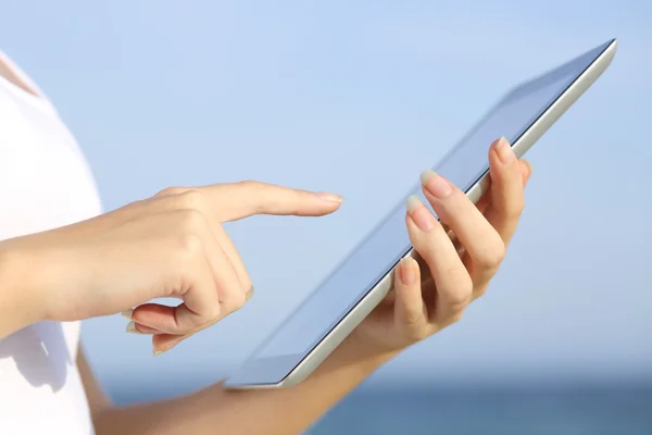 Profilo di una donna che tiene in mano e naviga su un tablet digitale in spiaggia — Foto Stock