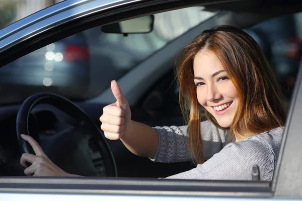 Mulher feliz dentro de um carro gesticulando polegar para cima — Fotografia de Stock