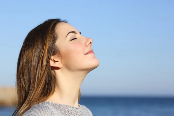 Vrouw staand ademhaling diep uitwaaien op het strand — Stockfoto