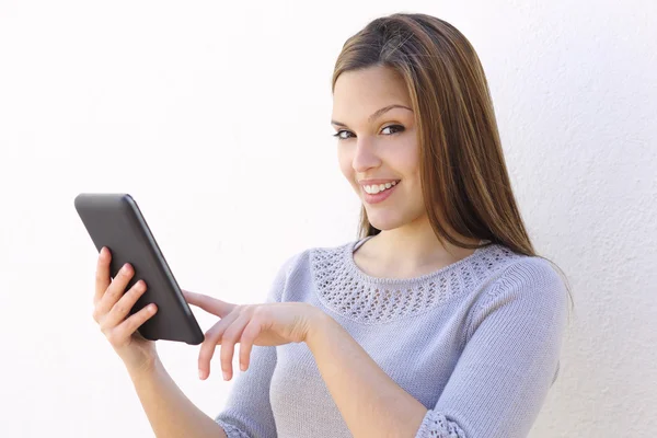 Hermosa mujer sosteniendo un lector de tabletas y mirando a la cámara —  Fotos de Stock