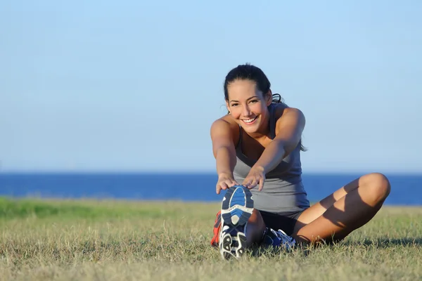 Fitness alergător femeie întindere pe iarbă — Fotografie, imagine de stoc