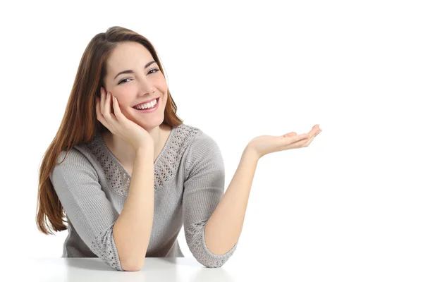 Mulher feliz apresentando com a mão aberta segurando algo em branco — Fotografia de Stock