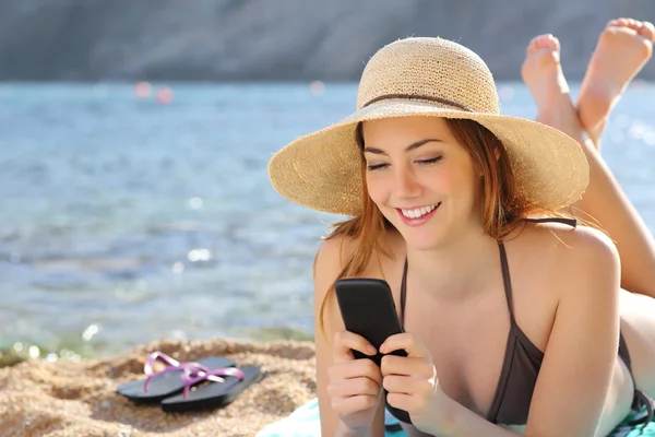 Frau am Strand im Sommer per SMS mit dem Smartphone — Stockfoto
