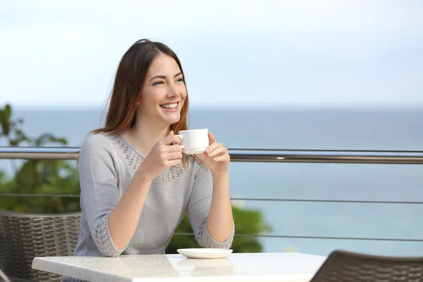 Hermosa mujer sosteniendo una taza de café en un restaurante — Foto de Stock