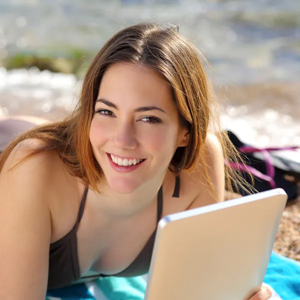 Mujer bastante feliz usando una tableta en la playa — Foto de Stock