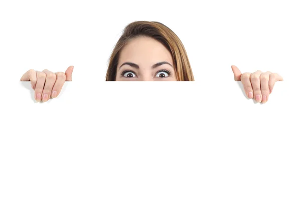 Surprised woman eyes over a blank promotional display Royalty Free Stock Images