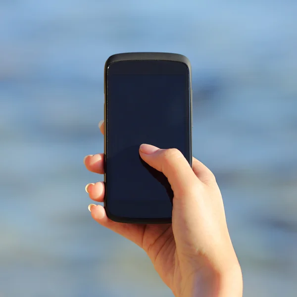 Mujer sosteniendo la mano y mostrando una pantalla de teléfono inteligente en blanco — Foto de Stock