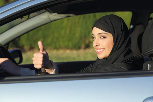 Glückliche arabische saudi Frau am Steuer eines Autos mit erhobenem Daumen — Stockfoto