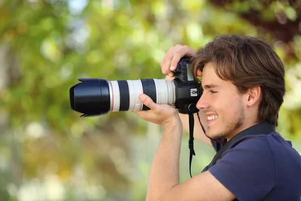 Fotógrafo tirando uma fotografia ao ar livre com uma câmera dslr — Fotografia de Stock