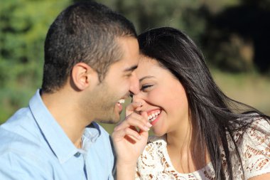 Arap rahat çift erkek ve kadın parkta mutlu gülüyor ve flört