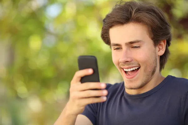 Hombre feliz sorprendido mirando el teléfono inteligente — Foto de Stock
