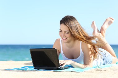 mutlu genç kız sahilde bir laptop sosyal medya tarama
