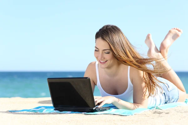 Menina adolescente feliz navegando nas mídias sociais em um laptop na praia — Fotografia de Stock