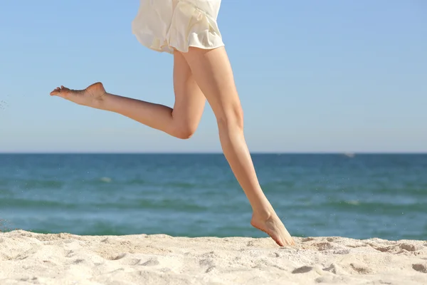 美丽的女人长腿跳跃在沙滩上 — 图库照片