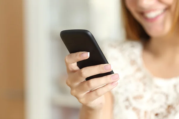 Primer plano de una mano de mujer usando un teléfono inteligente en casa — Foto de Stock