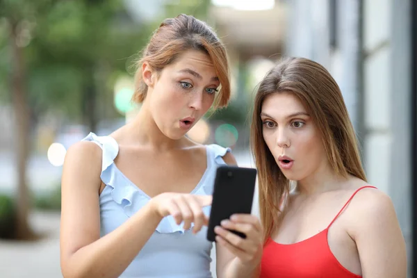 Dos Mujeres Sorprendidas Revisando Noticias Teléfonos Inteligentes Calle — Foto de Stock