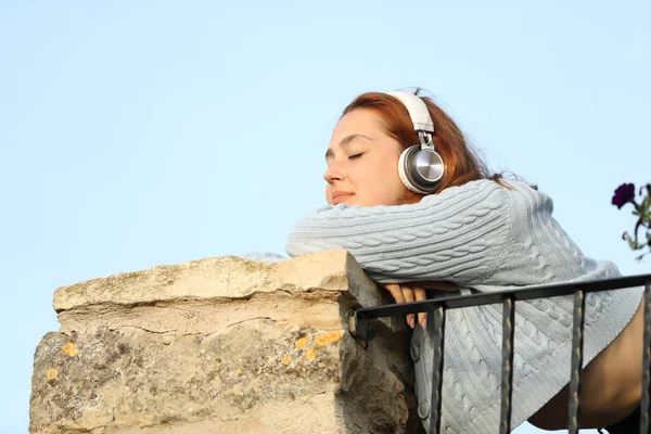 Ικανοποιημένη Γυναίκα Που Φοράει Ασύρματα Ακουστικά Ακούγοντας Μουσική Ξεκουράζεται Μπαλκόνι — Φωτογραφία Αρχείου