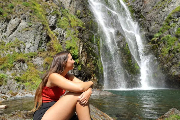 Mulher Feliz Sentada Sozinha Contemplando Uma Bela Cachoeira — Fotografia de Stock