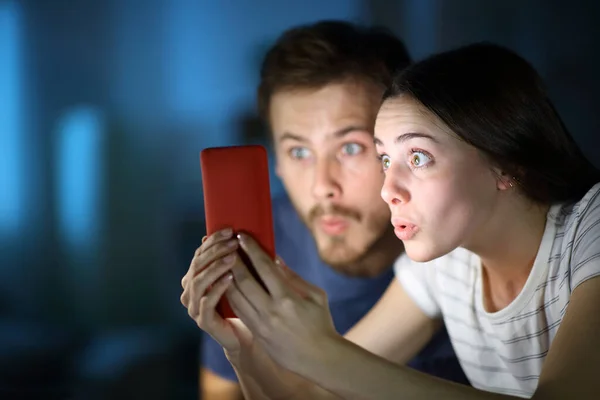 Casal Surpreso Verificando Telefone Inteligente Noite Casa — Fotografia de Stock