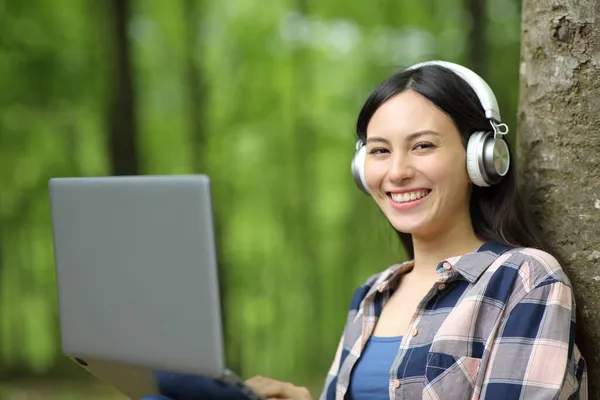 Aziatische Vrouw Met Laptop Koptelefoon Kijken Naar Zitten Een Park — Stockfoto