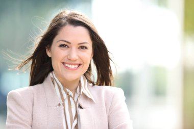 Caddede kameraya bakan mutlu bir yöneticinin portresi.