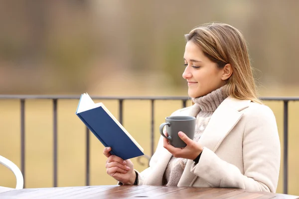 Расслабленная Женщина Читает Бумажную Книгу Пьет Террасе Зимой — стоковое фото
