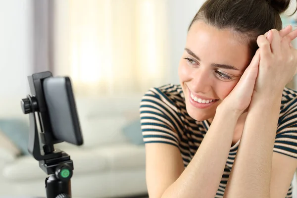 幸せな女性見ますビデオ上のスマートフォン座ってホーム — ストック写真