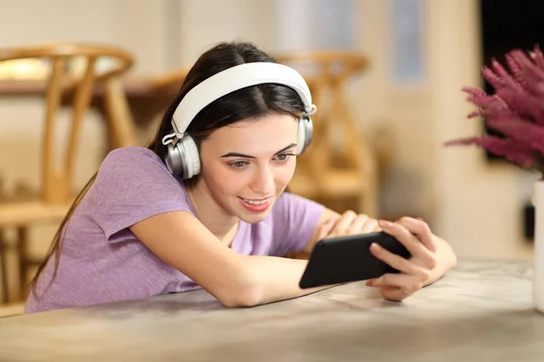 Happy Woman Home Wearing Headphones Watching Videos Smart Phone — Stockfoto