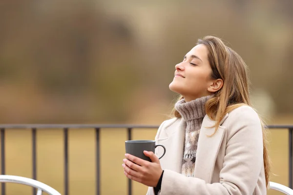 Lycklig Kvinna Som Håller Kaffemugg Och Andas Frisk Luft Vintern — Stockfoto