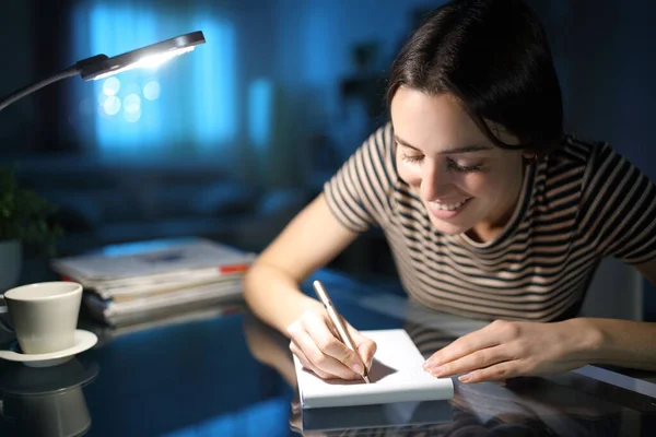 Щаслива Жінка Робить Нотатки Паперовому Ноутбуці Вночі Вдома — стокове фото