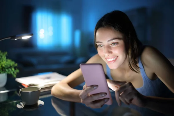 幸せな女性で夜チェックスマートフォンにホーム — ストック写真