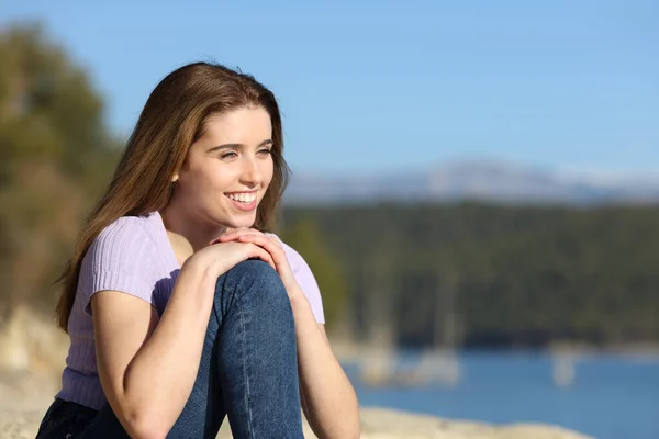 美しい湖に座っている景色を考える幸せな女性 — ストック写真