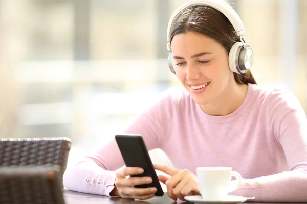 Kulaklık Takan Mutlu Bir Kadın Barda Müzik Dinleyen Akıllı Telefonları — Stok fotoğraf