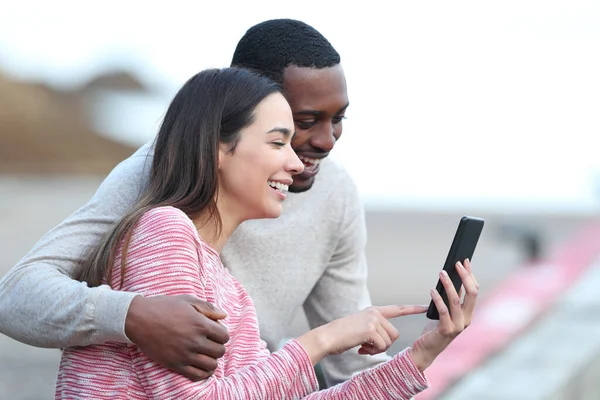 Feliz Pareja Interracial Comprobando Teléfono Inteligente Sentado Aire Libre — Foto de Stock