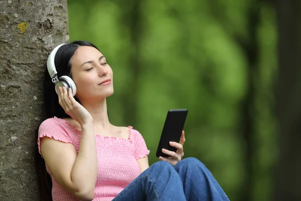 Asian Woman Listening Music Headphones Smart Phone Sitting Green Forest — Stock Photo, Image