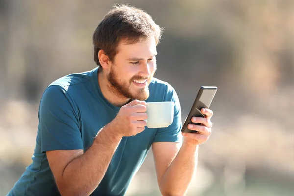 Happy Man Met Behulp Van Smartphone Online Inhoud Drinken Van — Stockfoto