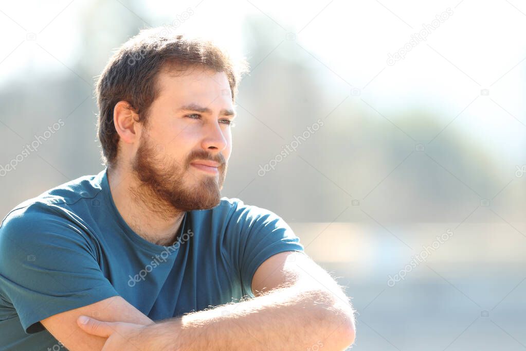 Pensive man contemplating views sitting outdoors