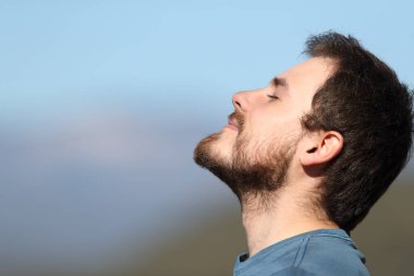 Yan görünüş, tatmin olmuş bir adamın temiz hava soluyan portresi.
