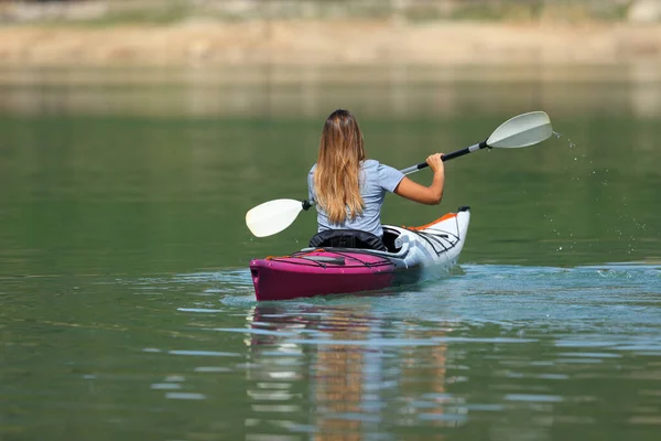 バックビュー夏休みに湖で漕ぐ女性カヤックの肖像画 — ストック写真