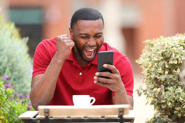 Spännande Man Med Svart Hud Kontroll Mobiltelefon Firar Bar Terrass — Stockfoto