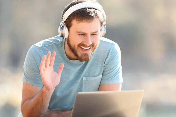 Happy Man Met Koptelefoon Begroet Met Zijn Hand Tijdens Een — Stockfoto